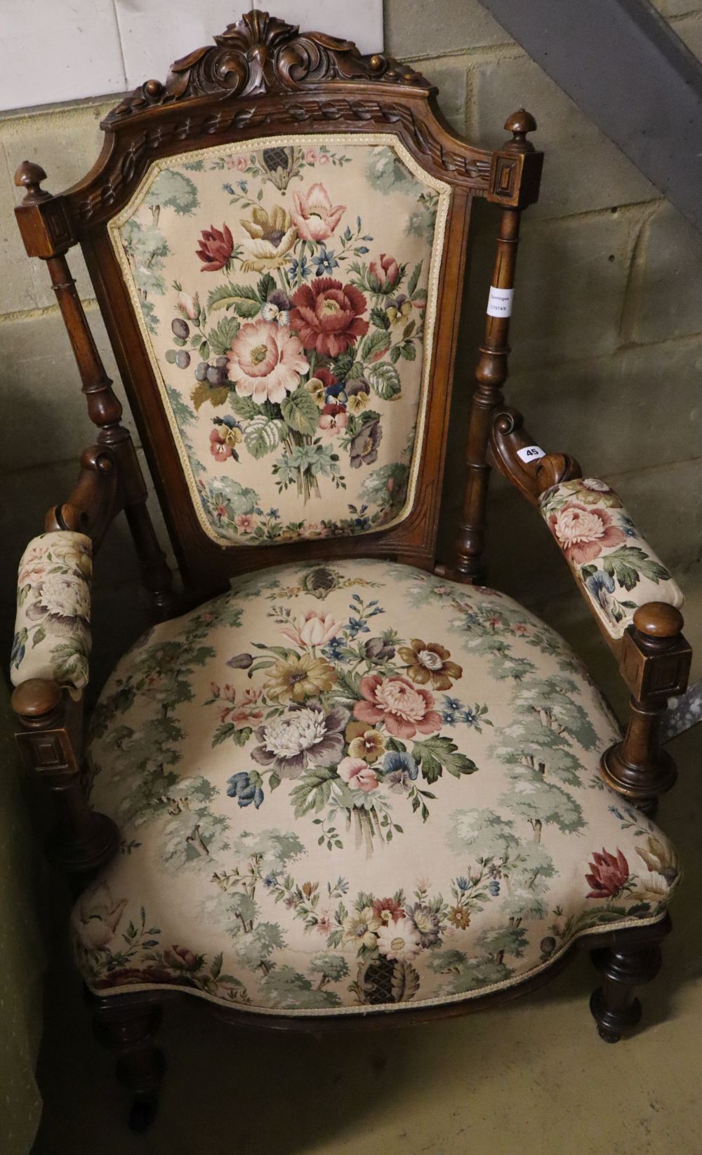 A late Victorian carved walnut upholstered open armchair